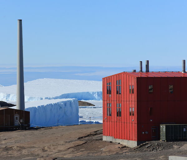 A red shed with icebergs and snow in the background